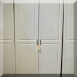 F63. White storage cabinets.
